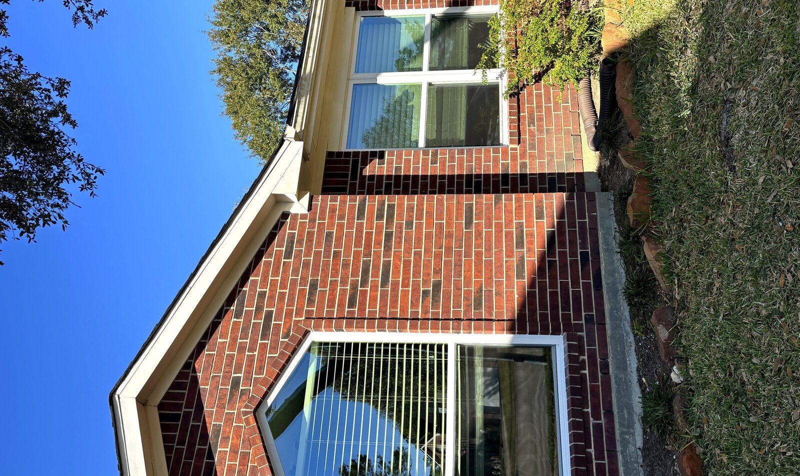 Custom angled-top window on brick home